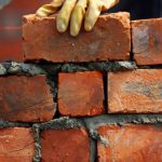 man building a brick wall